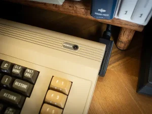 A photo of the top right quarter of a C64 using a right angle power adapter.